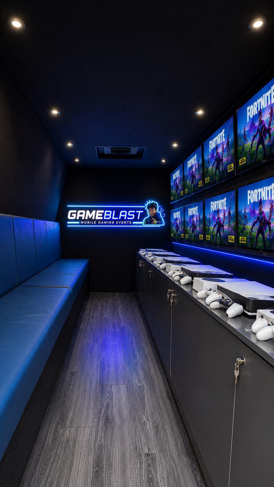Inside the GameBlast van showing blue bench seating, the glowing GameBlast neon sign, console stations and high-definition screens
